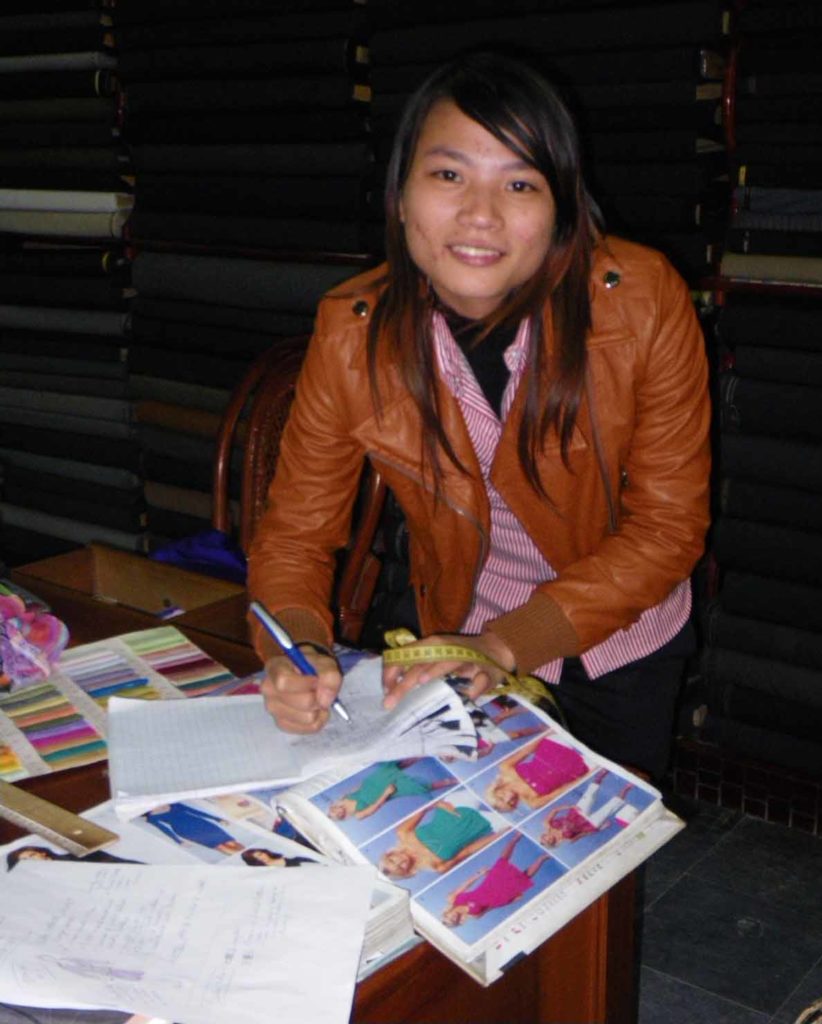 Hoi-an-Vietnam-sun-tailor-shop-saleswoman-writing-meaurements