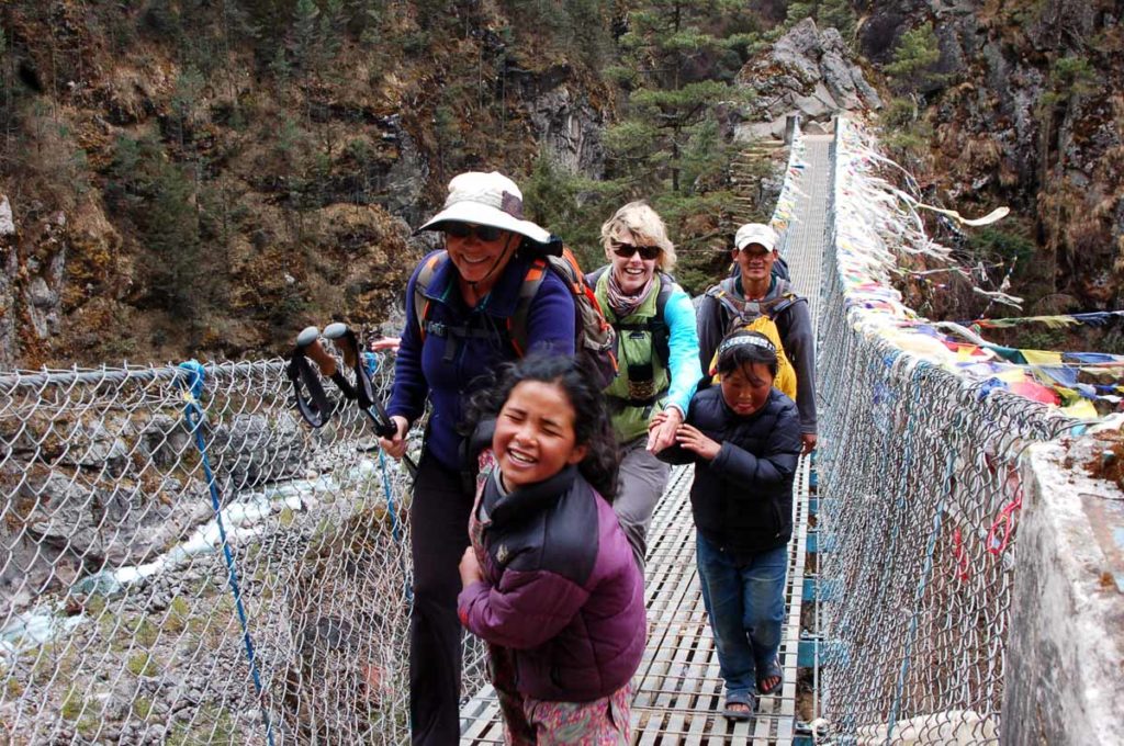 Nepal-trek-girls-helping-us-cross-suspension-bridge