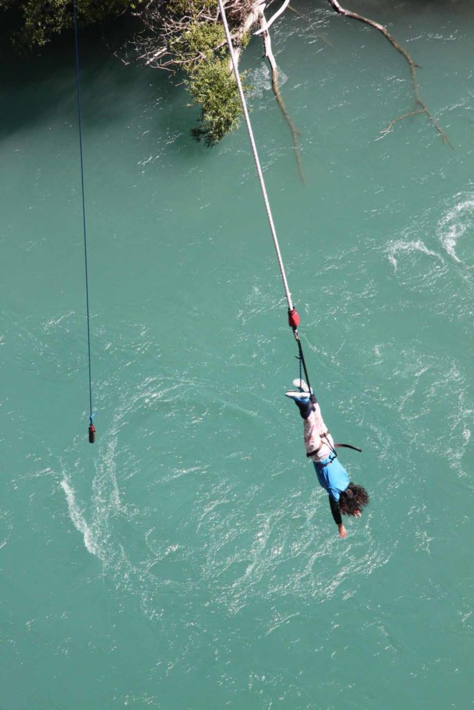 new-zealand-kawarau-bridge-bungy-jumper-hanging-by-river